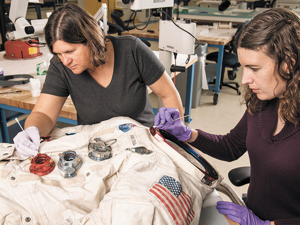    AG  Comments  Catch up  Editing Editing  Share Share: this file is shared     Calibri (Body) 11             General     Conditional Formatting          E74 Neil Armstrong's Apollo 11 bullky white spacesuit lies flat in a conservation laboratory as two museum conservators wearing gloves work on it with delicate tools and intense focus.  Neil Armstrong's Apollo 11 bullky white spacesuit lies flat in a conservation laboratory as two museum conservators wearing gloves work on it with delicate tools.