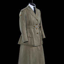 A women&#039;s military uniform comprised of a green wool coat with gold buttons and the WRAF insignia on the shoulders, and a matching green cap and skirt.